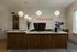 Chic coffee bar with modern pendant lighting and tiled wall, perfect for social gatherings and relaxation.
