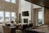 Chic living space with high ceilings, stone accent wall, and elegant fireplace, featuring a cozy seating area, stylish decor, and a billiard table, perfect for relaxation and entertainment.
