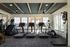Modern apartment gym with sleek exercise machines, vibrant natural light, and stylish ceiling design.