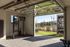 Contemporary home gym with diverse fitness equipment and an inviting view of the outdoor garden area.