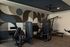 Modern apartment gym with sleek exercise machines and stylish abstract wall art, ideal for fitness enthusiasts.
