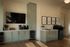 Chic modern kitchen area with elegant cabinetry, stylish shelving, and a wall-mounted TV, perfect for culinary creativity and relaxation.