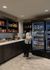Chic pantry nook with elegant dark wood cabinetry and a modern refrigerator stocked with snacks and beverages, perfect for convenient living.