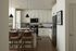 Elegant modern kitchen with sleek white cabinetry, stainless steel appliances, warm wooden flooring, and a cozy breakfast bar with stylish pendant lighting.