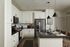 Elegant modern kitchen with sleek black countertops, stainless steel appliances, and stylish pendant lighting, creating a warm and inviting space for culinary creativity.