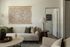 Elegant living room with cozy neutral-toned sofa, decorative pillows, and artistic wall tapestry, creating a warm and inviting atmosphere.