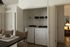 Chic apartment space featuring a convenient in-unit laundry area with modern appliances, adjacent to a warmly lit room.