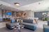 Contemporary living space featuring a sleek open kitchen, stylish gray sofas, and vibrant artwork, ideal for modern gatherings.