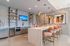 Luxurious contemporary kitchen with sleek metallic finishes, elegant pendant lighting, and stylish bar seating.
