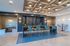 Contemporary dining and seating area with modern lighting, featuring elegant blue and beige decor and a stylish coffered ceiling.