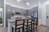 Modern kitchen with sleek gray cabinets, granite countertops, and island seating for four under stylish pendant lighting.