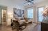 Inviting living room with modern decor, featuring cozy seating, stylish artwork, and a light-filled atmosphere.