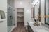 Luxurious bathroom with sleek glass shower, modern vanity, and spacious walk-in closet.