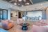 Luxurious lounge area featuring stylish pink armchairs, elegant lighting, and a chic bar with blue stools.