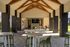 Chic outdoor entertainment area with modern seating, a ping pong table, and stylish architecture under wooden beams.