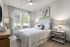 Apartments in Birmingham For Rent - Tributary Rise - Bedroom With Carpeted Flooring, Large Bed, Nightstands With Lamps, Dresser, Ceiling Fan With Light, And Windows With Blinds And Coverings.