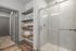 furnished standing shower and shelving in bathroom in apartment home
