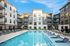 2-Bedroom Apartments in Birmingham, AL - Tributary Rise - Resort-Style Saltwater Pool with In-Pool and Pool-Side Lounge Seats, and View of Apartment Buildings.