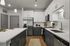 Modern kitchen featuring sleek cabinetry, stainless steel appliances, and a spacious quartz countertop island, perfect for entertaining.
