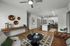 Modern open-concept living room with stylish decor, featuring a chic kitchen island, elegant lighting, and cozy seating area with contemporary art.