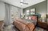 Chic bedroom with a plush bed, stylish green accent wall, and elegant decor, perfect for a cozy and modern living space.