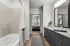 Elegant bathroom with sleek vanity, modern fixtures, and view into a cozy bedroom.