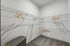 Spacious walk-in closet with ample wire shelving, stylish wooden hangers, and cozy carpet flooring.
