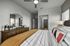 Inviting bedroom with stylish decor, featuring a modern dresser and a cozy bed with colorful accent pillows.