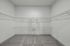 Spacious walk-in closet with sleek wire shelving and plush carpet, perfect for luxurious storage solutions.