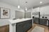 Modern kitchen with a sleek island, elegant cabinetry, stainless steel appliances, and contemporary pendant lighting.