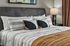 Inviting and stylish bedroom with cozy decor, featuring a plush bed, elegant pillows, and warm ambient lighting.