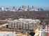 Modern apartment complex with a stunning city skyline backdrop, showcasing urban living with luxury and convenience.