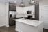 Modern kitchen with sleek stainless steel appliances, elegant black and white cabinetry, and a spacious island with a built-in sink.