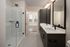 Elegant modern bathroom showcasing double sinks, sleek glass shower, and trendy lighting fixtures.