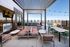 Luxurious rooftop patio with plush seating, stylish pergola, and panoramic city views; perfect for entertaining and relaxation.