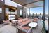 Chic rooftop lounge with modern seating, a flat-screen TV, and panoramic city views, perfect for entertaining.