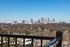 Breathtaking city skyline view from a balcony, showcasing vibrant urban landscape and clear blue skies.