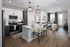 Modern open-plan kitchen and living room with sleek design, featuring elegant lighting, stylish hardwood floors, and a cozy seating area with city views.