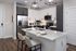 Sleek modern kitchen featuring a center island with elegant bar seating, stainless steel appliances, and minimalist cabinetry.