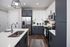 Modern kitchen with sleek cabinetry, stainless steel appliances, and elegant white countertops, featuring stylish pendant lighting and hardwood floors.