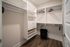 Spacious walk-in closet with modern shelving, hanging rails, and sleek hardwood flooring, perfect for all your storage needs.