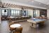 Luxurious open-concept entertainment room featuring a modern kitchen with bar seating, stylish lounge area, and billiards table, perfect for social gatherings.