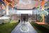 Vibrant mural-adorned space with lush greenery and an artistic ceiling design, offering a unique ambiance and a ping pong table for recreation.