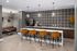 Chic apartment lounge with stylish bar seating, modern lighting, and a bold geometric backsplash.