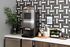 Sleek kitchen corner featuring a modern coffee machine, stylish geometric backsplash, and an elegant countertop setup with cups and condiments.