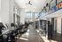 Bright and modern fitness center with state-of-the-art equipment, high ceilings, and large windows for natural light.
