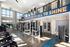 Bright and modern fitness center with floor-to-ceiling windows, state-of-the-art exercise equipment, and motivating signage.