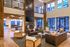 Luxurious open-concept living area with high ceilings, elegant leather sofas, and large windows providing abundant natural light.