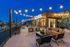 Chic rooftop lounge with string lights offering stunning river and city skyline views, perfect for relaxation and social gatherings.