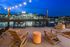 Charming rooftop patio with cozy seating and breathtaking city skyline views at dusk.